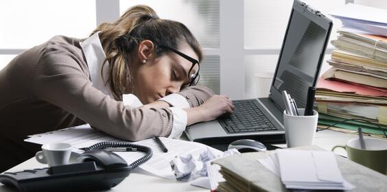 A woman having a hard time at work, sleeping on her laptop. 